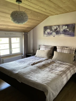 Chambre avec lit 180x200 et décoration magnolia dans le gîte Le Benouchon